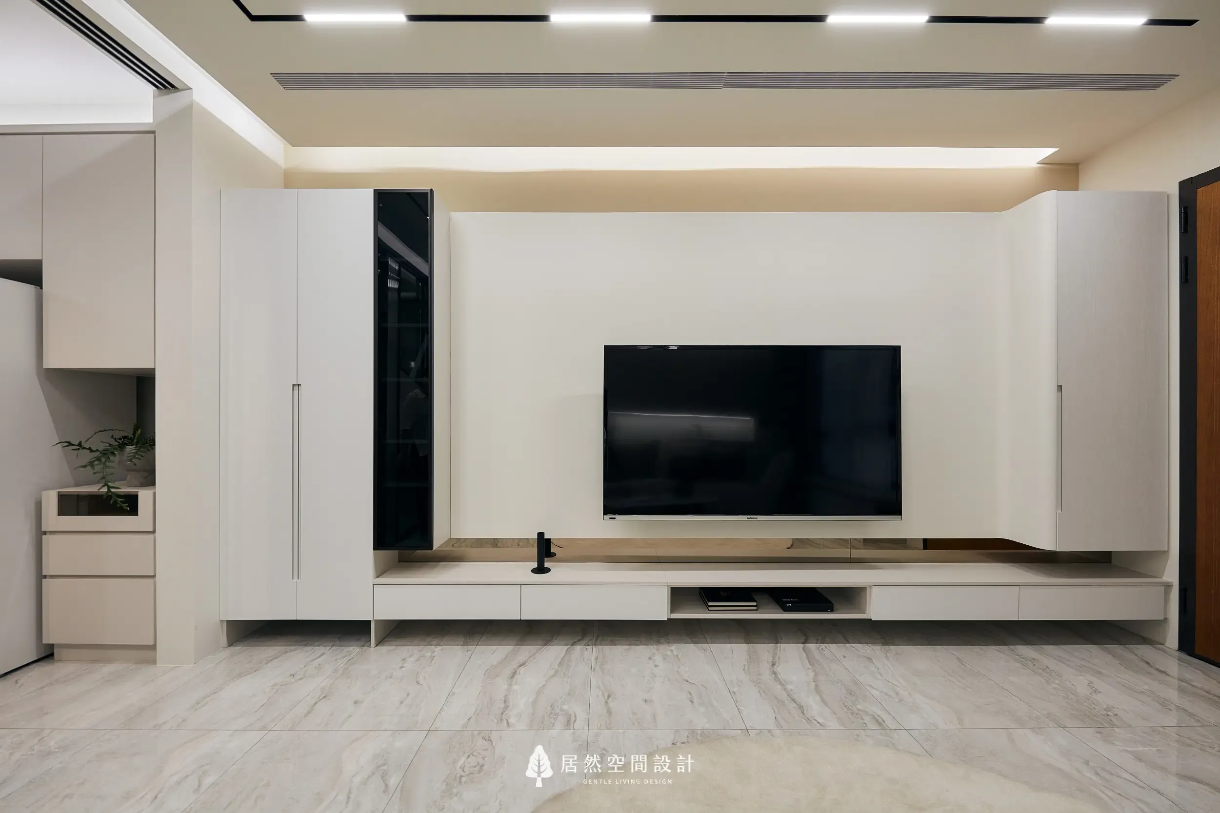 客廳電視牆以白色系與磁吸式軌道燈搭配,融入懸浮式電視櫃與左右高櫃,打造收納與展示並具的輕奢風格,視覺簡約俐落且富有層次。