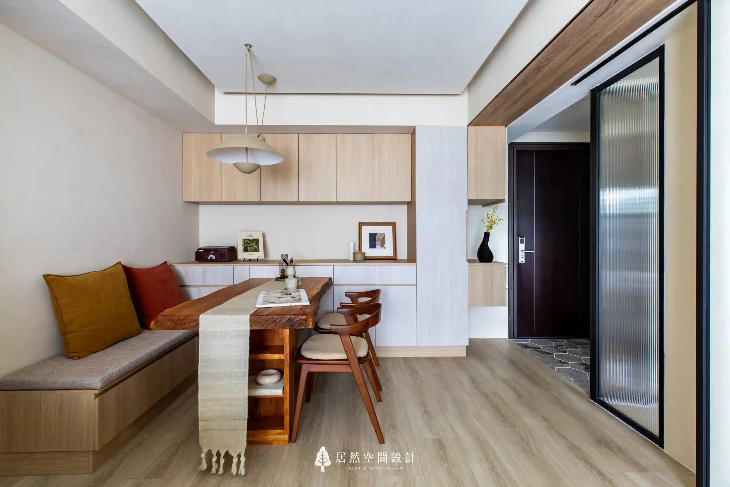 23坪北歐風新成屋3房2廳2衛｜原木質感餐桌搭配轉角長凳與壁面收納餐邊櫃，營造溫馨用餐區氛圍，融入展示屋主旅行收藏的生活風景