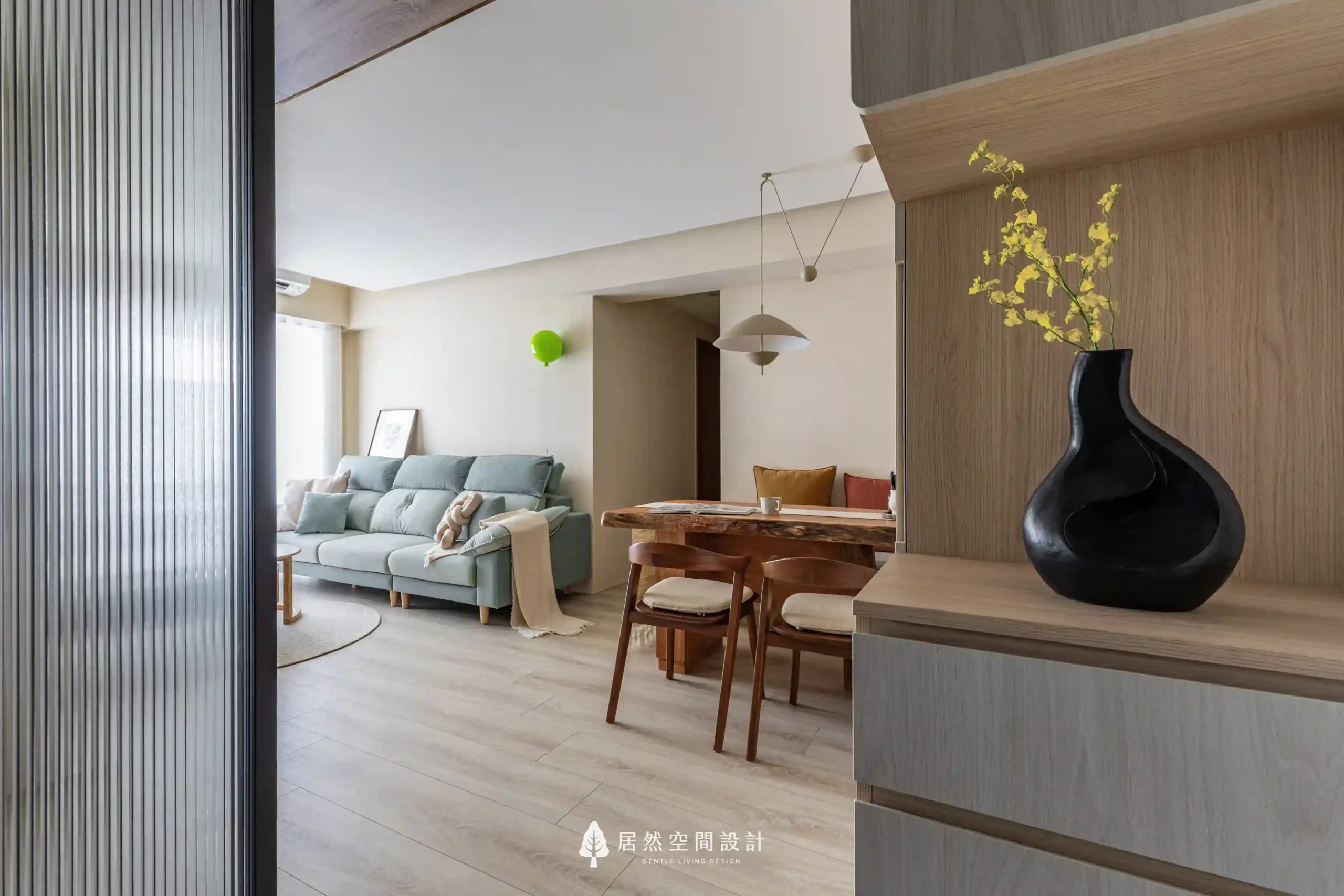 23坪北歐風新成屋3房2廳2衛｜從玄關望向客餐廳動線，格柵玻璃界定空間，木質語彙延伸至開放客廳與實木餐桌，營造明亮柔和生活感