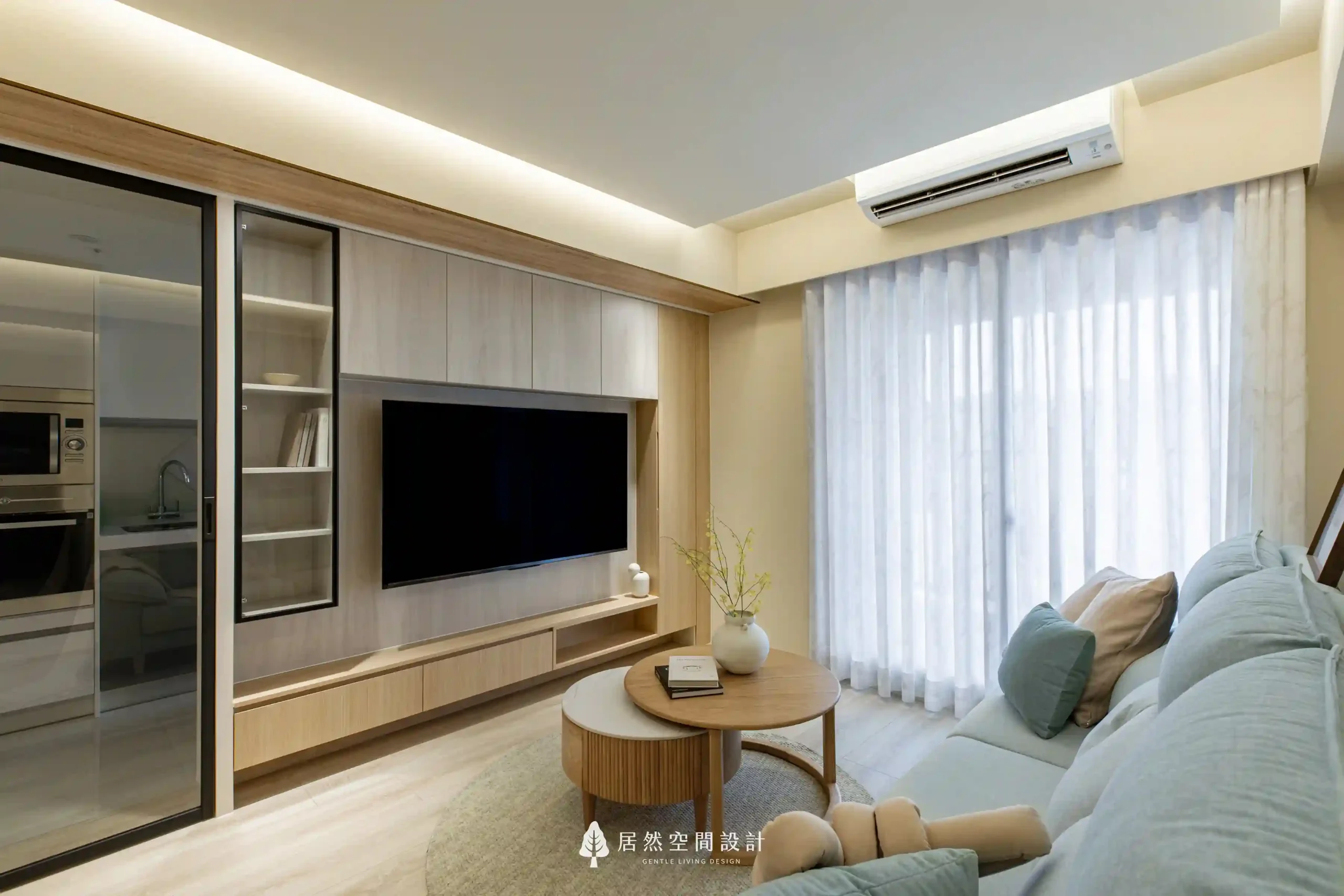 23坪北歐風新成屋3房2廳2衛｜電視牆結合木質櫃體與玻璃展示櫃，搭配柔光紗簾與溫潤木地板，勾勒簡約舒適的客廳生活感