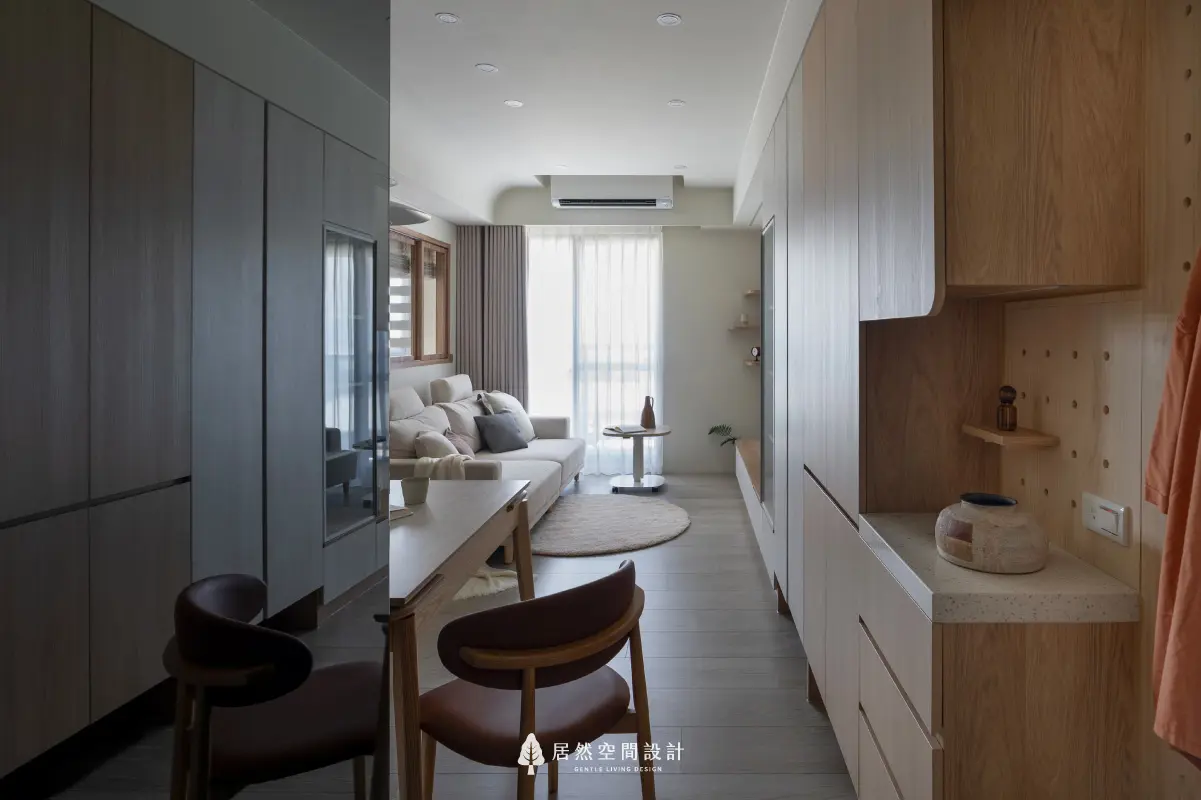18坪北歐風小宅2房2廳2衛|從玄關望向客廳,串連收納櫃、用餐桌與沙發區,空間色調延續木質與米白,帶出視覺一致的溫潤生活感。