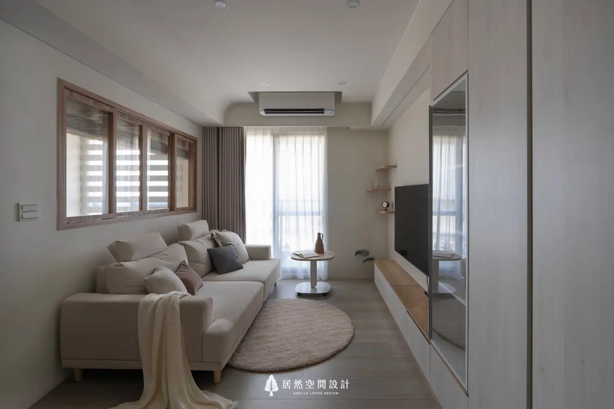 18坪北歐風小宅2房2廳2衛|圓弧天花與木框玻璃窗柔化空間線條,客廳串聯陽台光感,搭配米白沙發與木質櫃體,展現溫潤簡約風格。
