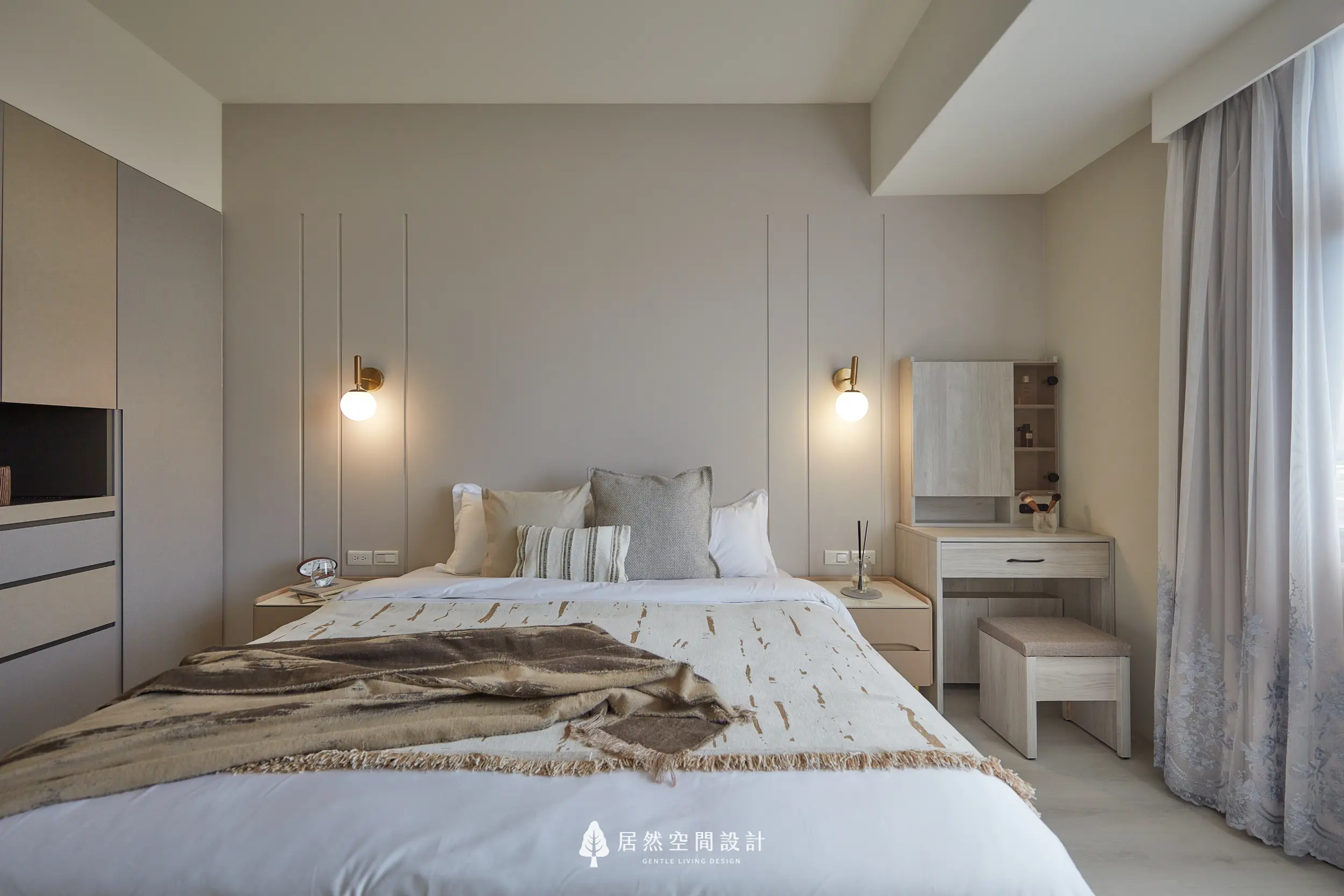 主臥以床頭線板與壁燈構成視覺重心，柔和中性色搭配梳妝桌機能，結合窗邊採光，營造沉靜放鬆且比例舒適的睡眠空間