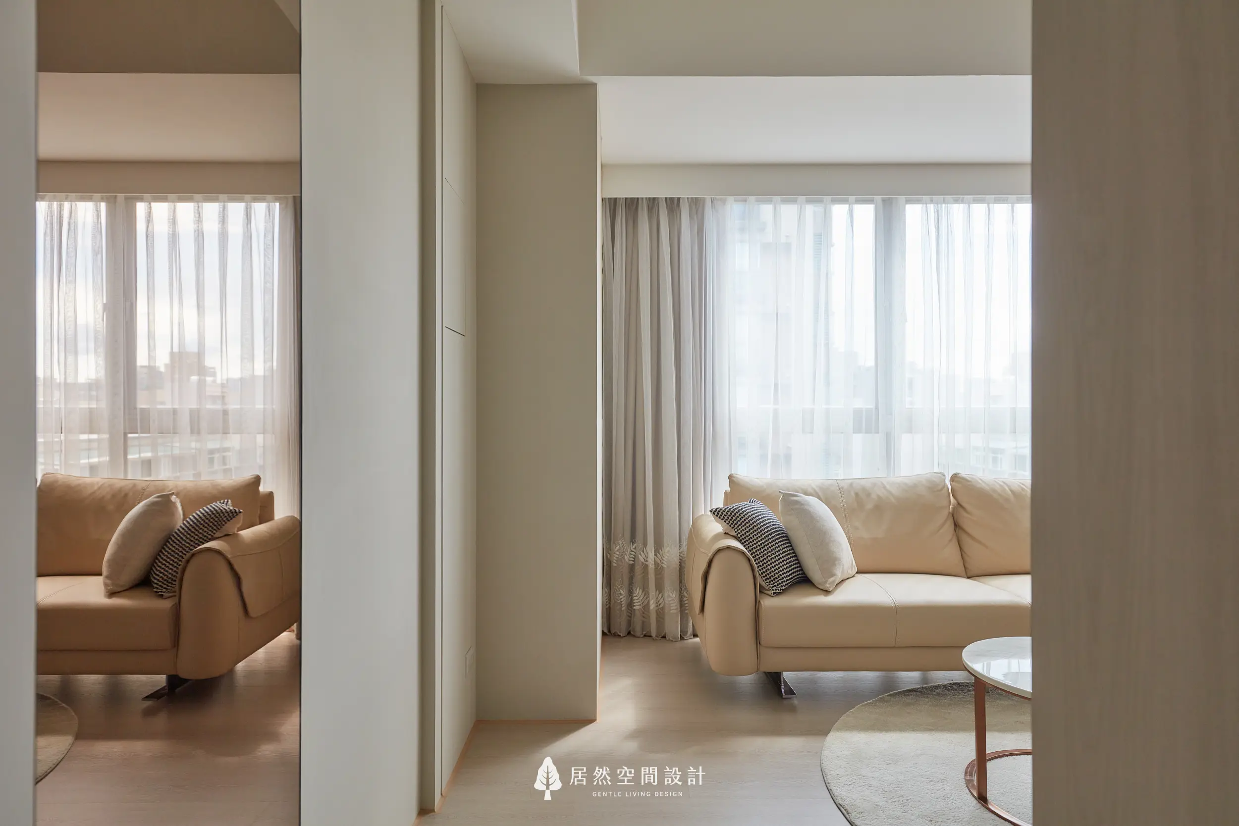 以米白與淺木色鋪陳客廳，沙發與窗簾形成柔和光感，利用鏡面延伸視覺，營造通透安定的日常空間氛圍，展現北歐簡約生活感受與舒適尺度