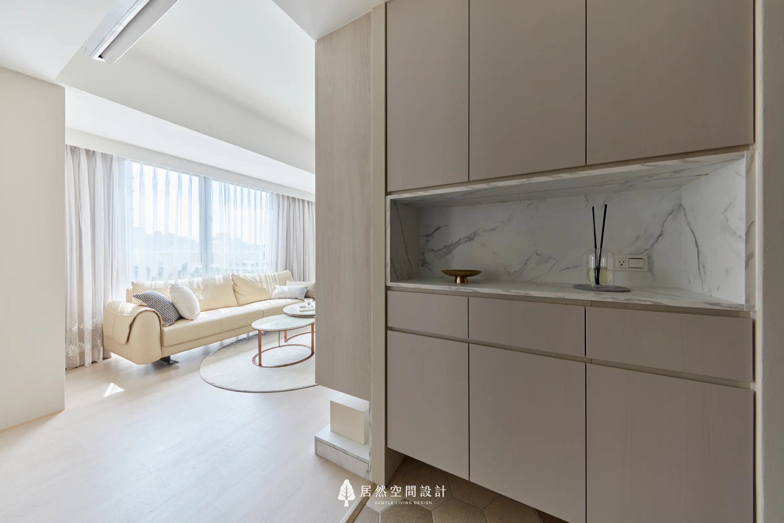 玄關收納櫃結合石紋檯面與展示層，界定客廳動線，引光入室，維持整體清爽秩序與生活實用性，兼顧視覺延伸與機能收整細節溫潤耐看度