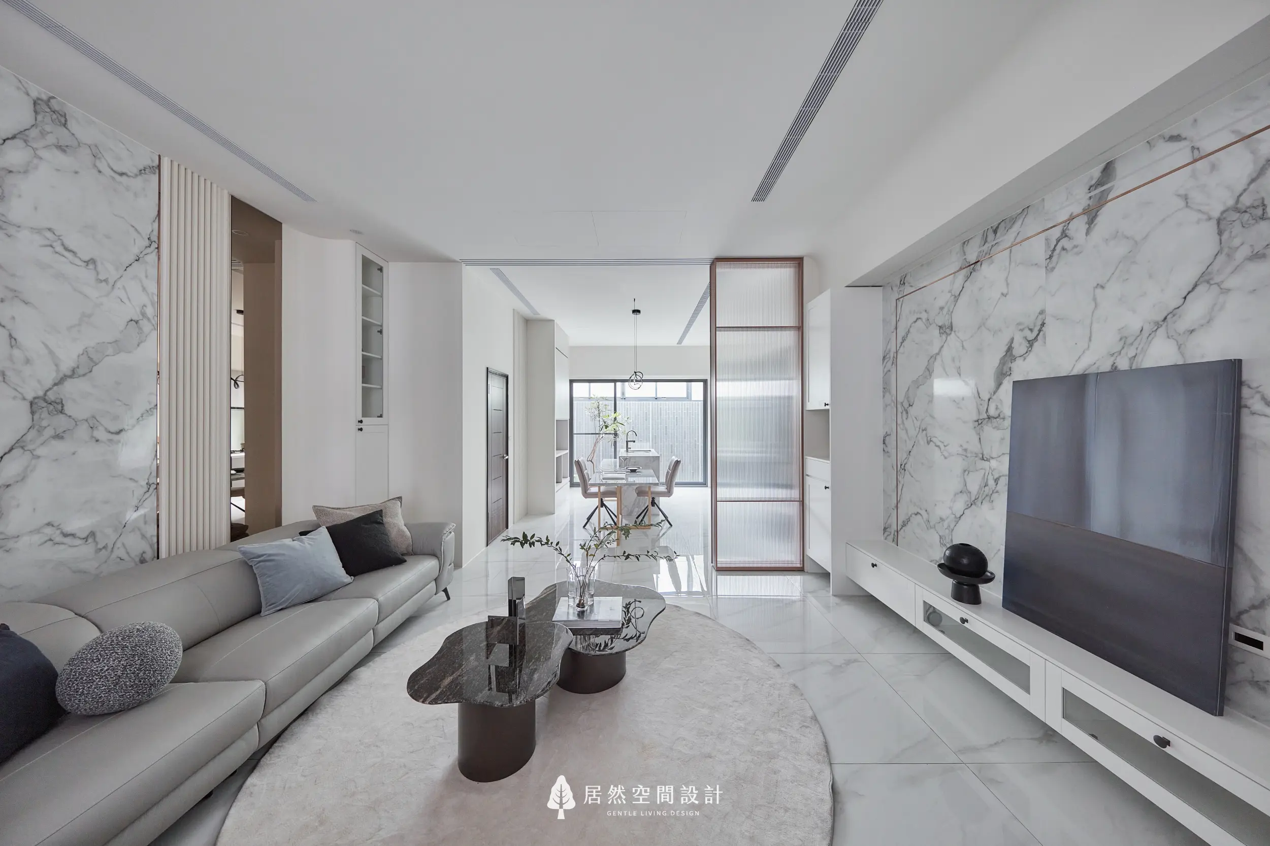 客廳以大理石紋理電視牆延伸整體空間視覺，搭配米色沙發與深色石紋茶几形成層次，長虹玻璃拉門串聯餐廳與採光動線
