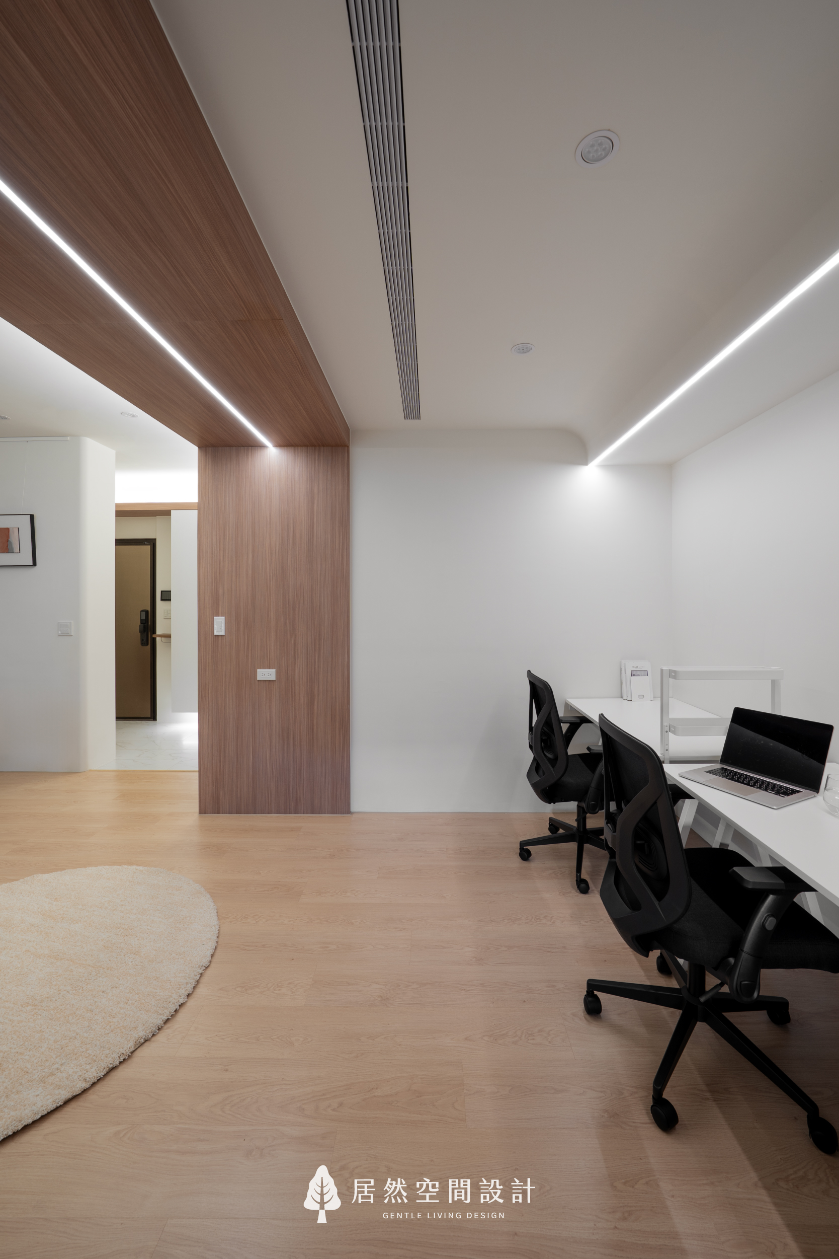 現代風室內設計工作區，居然空間設計以胡桃木天花延伸至立面劃分場域，結合嵌入式線性燈條與簡潔白牆，展現極簡空間的層次美感。