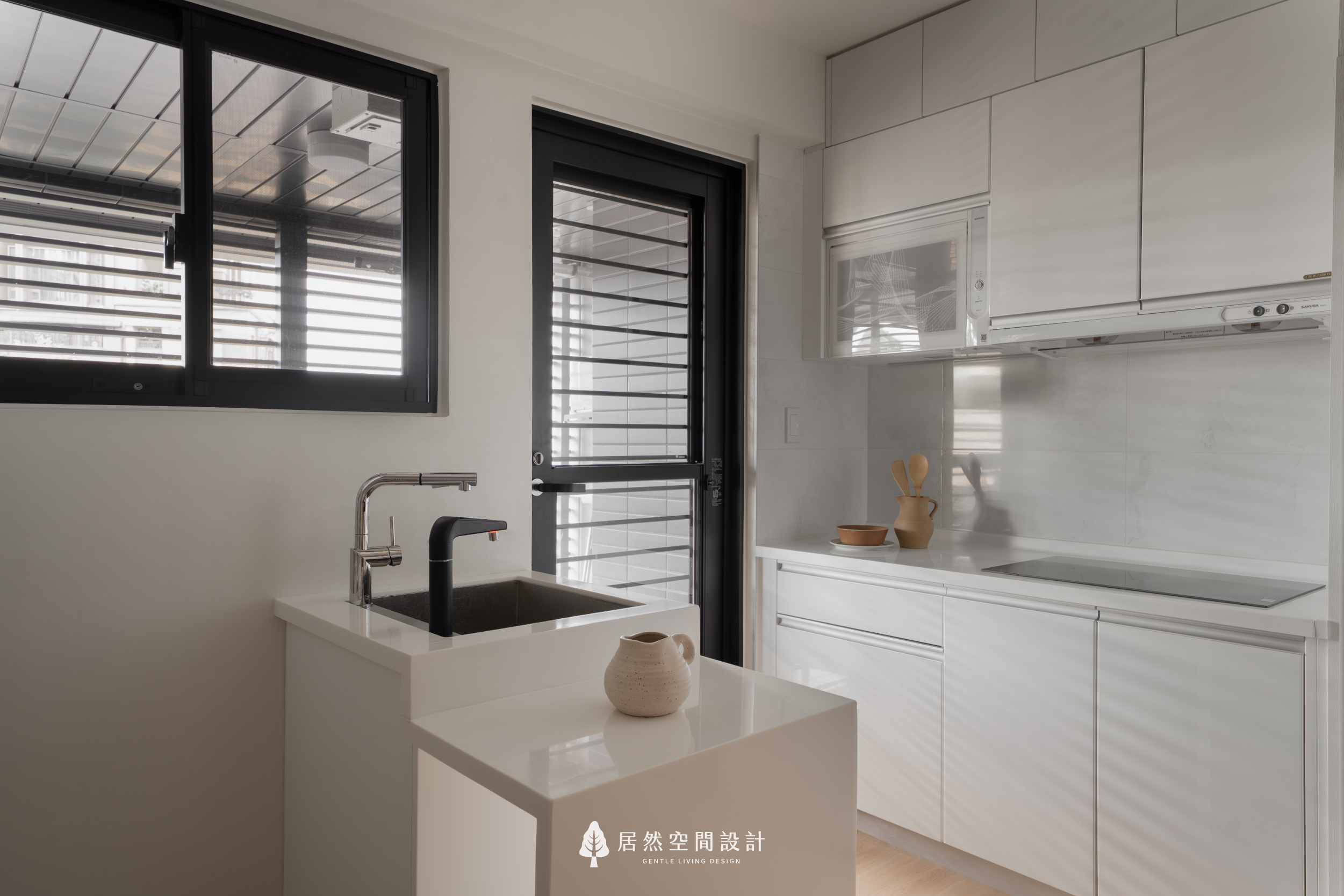 現代風廚房室內設計，以純白一字型系統廚具與多功能小中島，結合大面積採光與簡潔線條，打造明亮通透且具備流暢烹飪動線的機能料理空間。