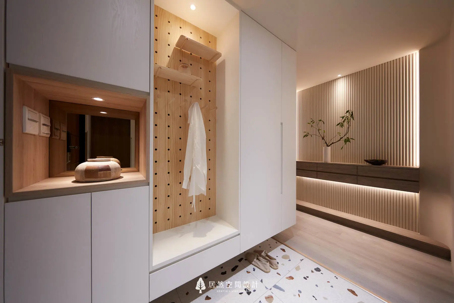 居然空間設計的日式風格玄關全景。圓弧門片與燈條置物平台，搭配個性化水磨石地板，展現弧光靜影作品中雙段式弧形燈光層次與歸家儀式感。