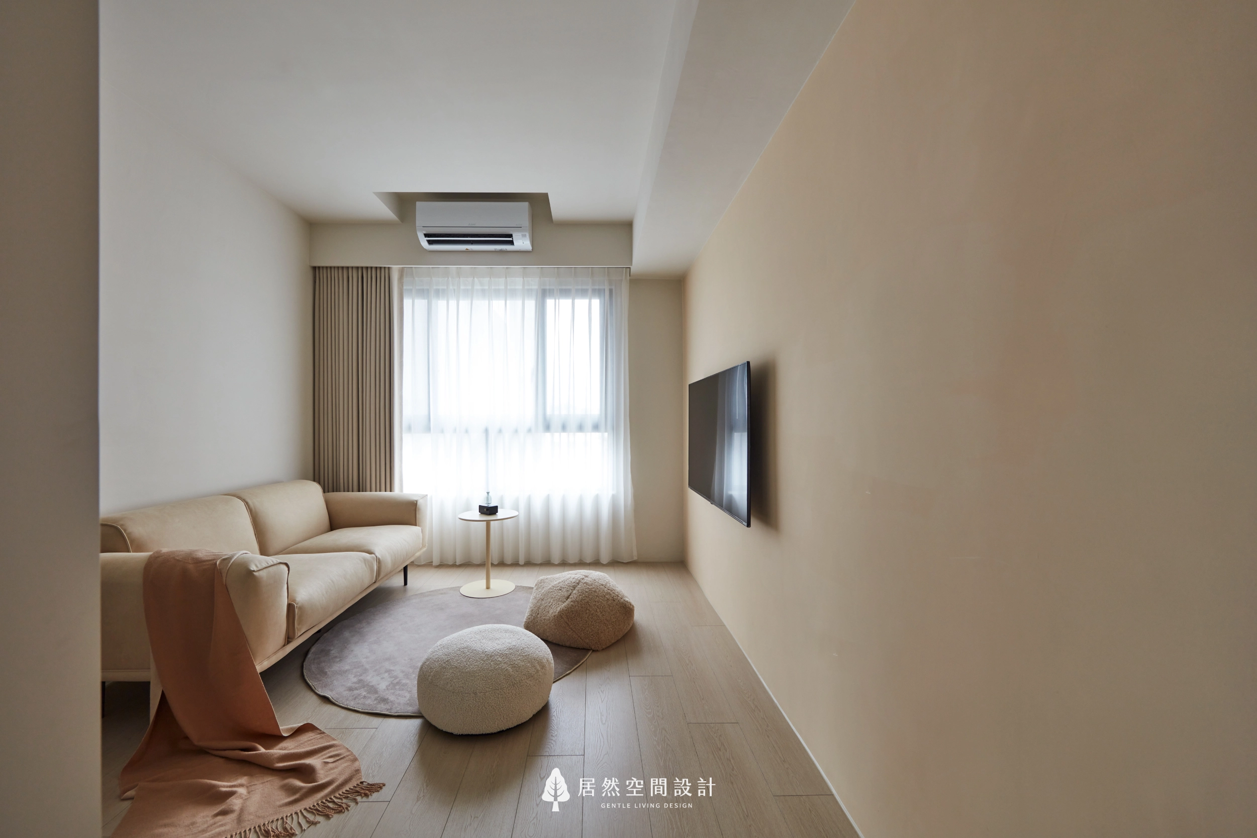 台中13坪北歐風新成屋客廳設計,以奶茶色牆面搭配淺色木地板、柔軟沙發與紗簾引入自然採光,結合壁掛電視與簡約家具配置,營造溫暖舒適且放鬆療癒的小坪數生活空間。