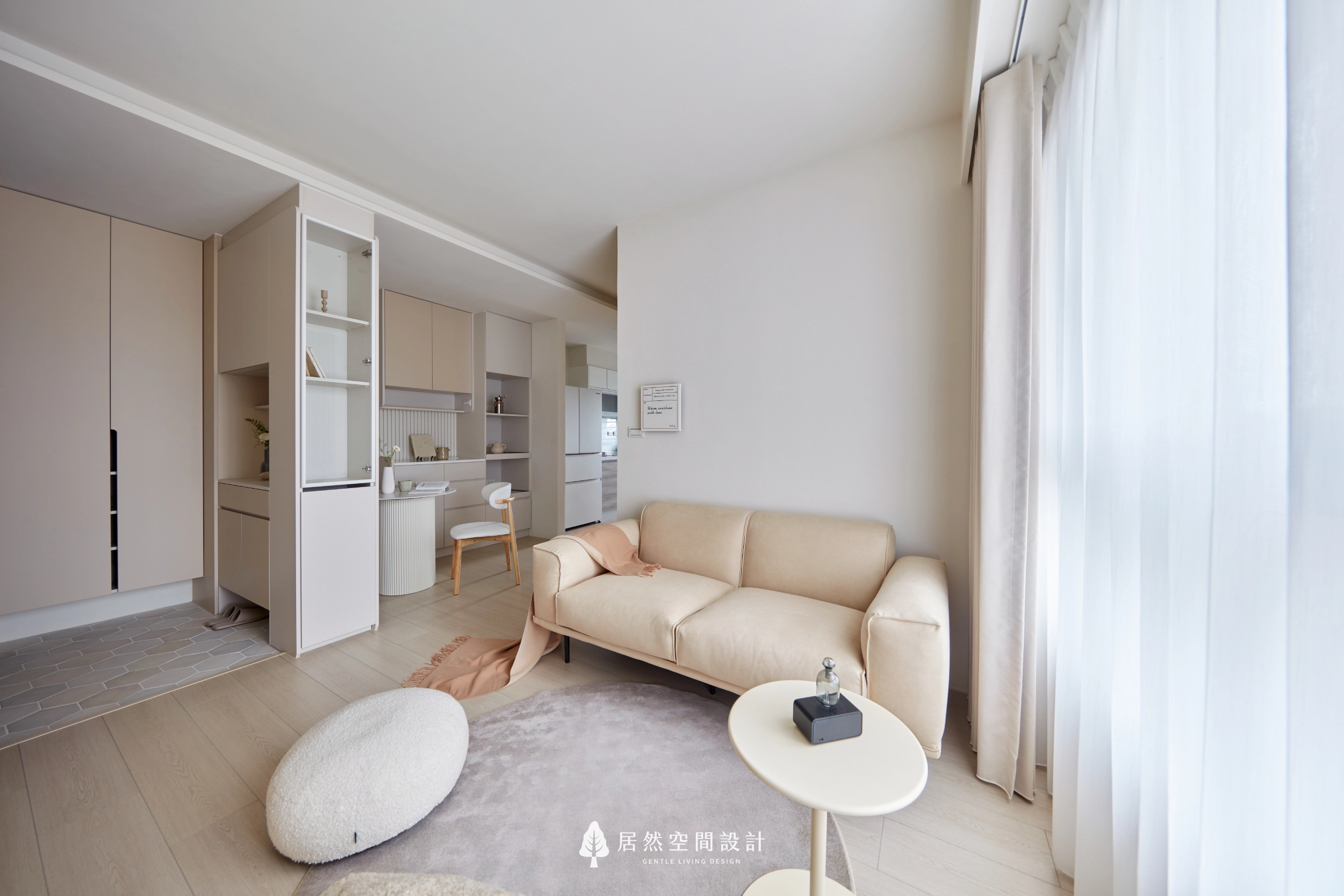 台中13坪北歐風新成屋客廳設計,奶茶色沙發搭配淺木地板、柔和地毯與大片落地窗採光,串聯玄關、餐廳及廚房開放式格局,營造溫暖明亮且富有生活感的小坪數住宅。