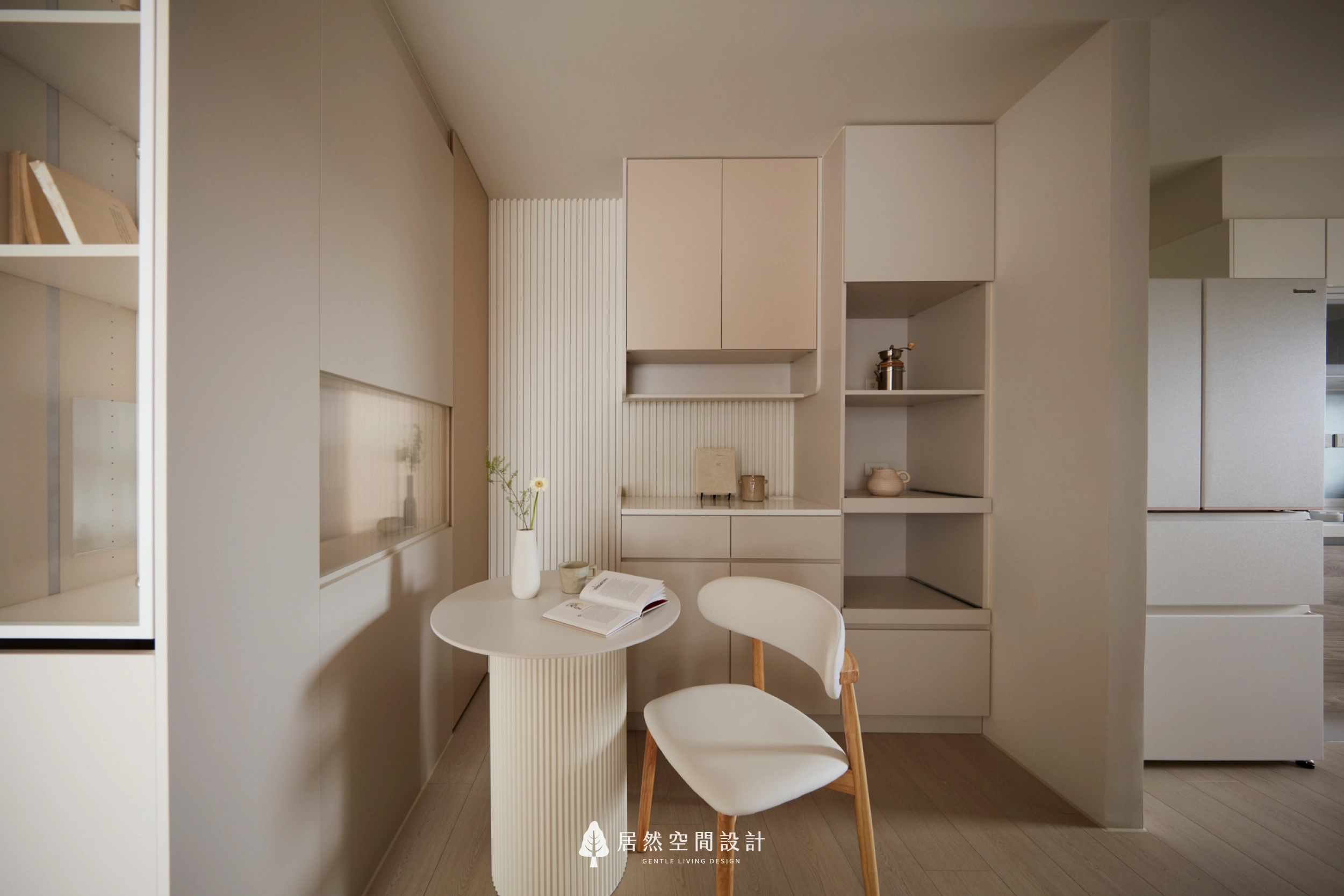 台中13坪北歐風新成屋餐廳設計,奶茶色收納櫃結合開放層架、圓形餐桌與格柵造型背牆,搭配自然木質餐椅與柔和光線,打造兼具用餐、閱讀與收納機能的溫馨生活空間。