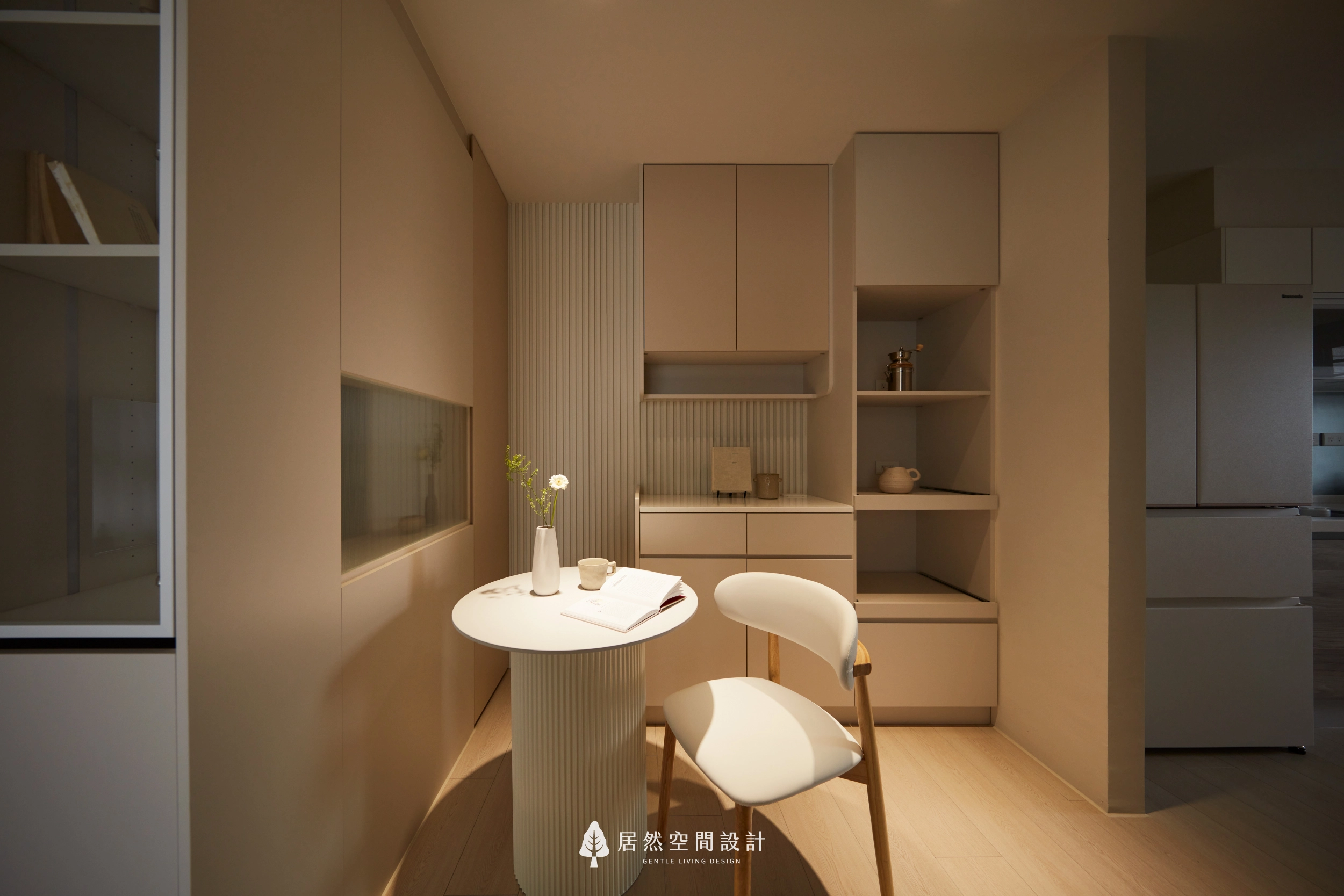 台中13坪北歐風新成屋餐廳設計,以圓形餐桌搭配奶茶色收納櫃、格柵造型背牆與展示層架,結合暖色間接照明與簡約家具配置,營造溫馨舒適且富有生活儀式感的用餐空間。