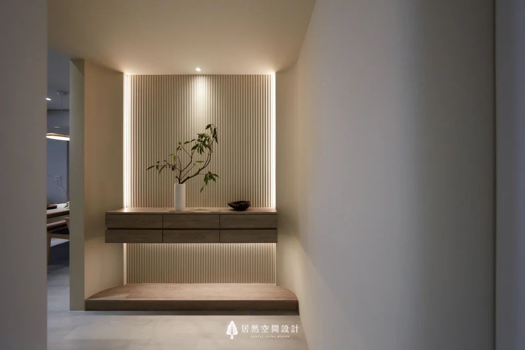玄關格柵端景設計，以垂直格柵搭配懸浮櫃與燈光，營造簡約且具有層次感的居家空間