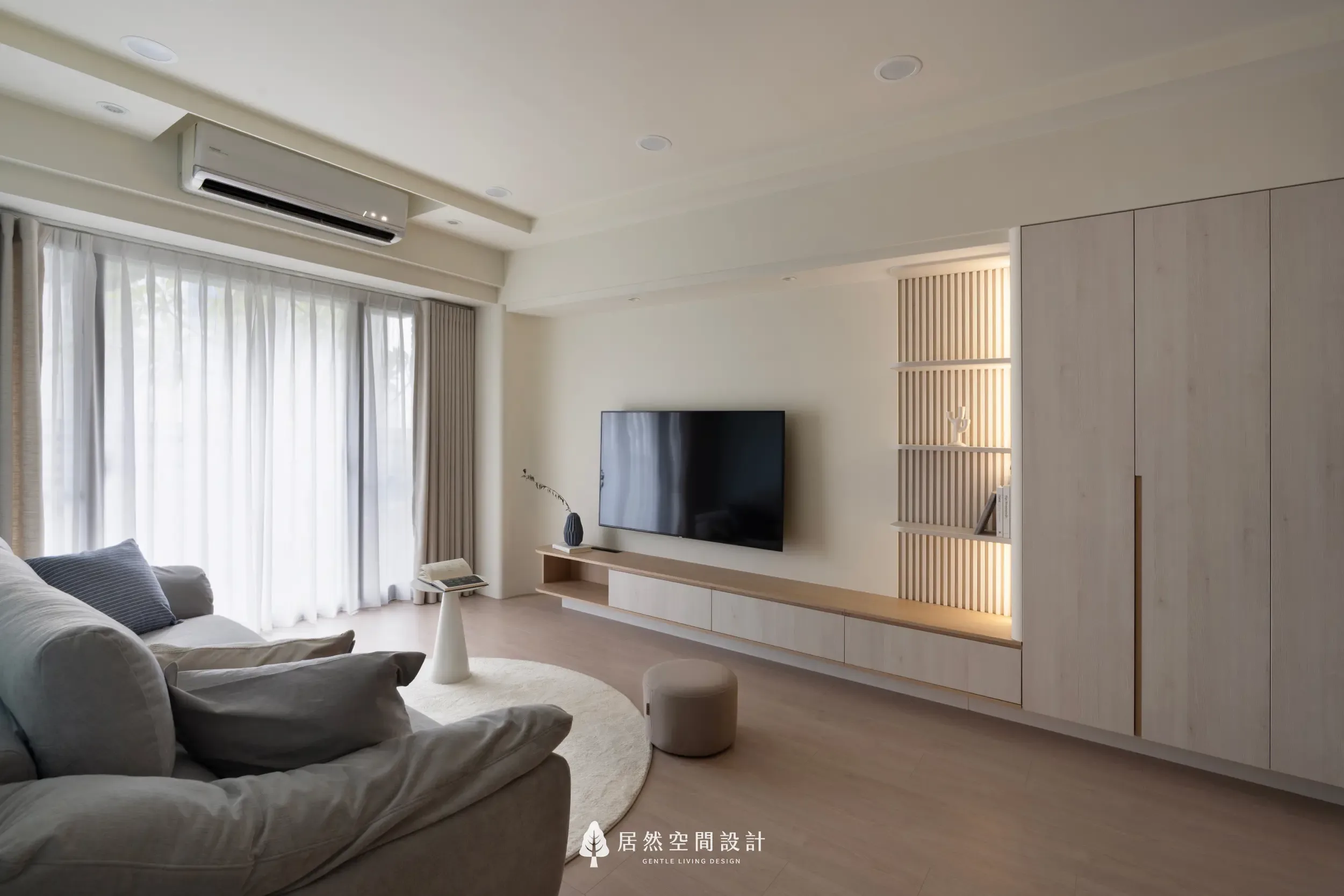 客廳格柵電視牆設計，以垂直線條搭配電視櫃與收納櫃，增加牆面層次並延伸空間比例
